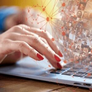 Närbild av en hand med rödmålade naglar som klickar på tangentbordet på en bärbar dator. I bakgrunden syns personens suddiga hand med en blå långärmad tröja. Från datorn strömmar nätverkssymboler och bilder på människor. Bilden används som produktbild till ett bas-paket för undersköterskor.