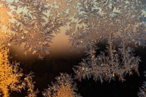 Vackra frostrosor och isblommor som bildats på en yta, bidrar till sidans visuella design.