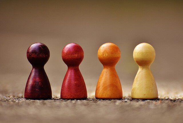 Fyra fiapjäser på rad i varma färger, från mörkröd och röd till orange och elfenbensfärgad. Bilden bidrar till namnsdags-inläggets visuella design.