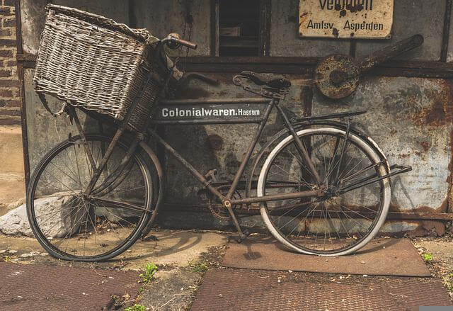 vintage-bicycle-with-woven-basket-leaning-against-wall-640×439