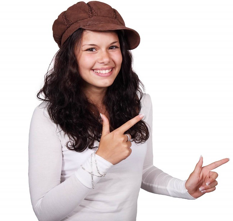 Ung flicka med långt mörkt hår, iklädd en långärmad vit t-shirt och en brun keps. Hon har silverlänkar runt höger handled och pekar med båda pekfingrarna snett upp åt höger i bilden. Vit bakgrund. Används på startsidan för att peka på webbplatsens namn.